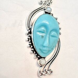2 1/2 inch, Carved Face, Blue Agate, Rainbow Moonstone pendant on silver chain.